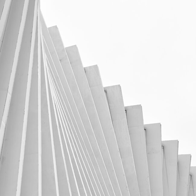Porzioni B/N series by Sofia Dell'Aversano Orabona: white pleated architectural fins against a pale sky